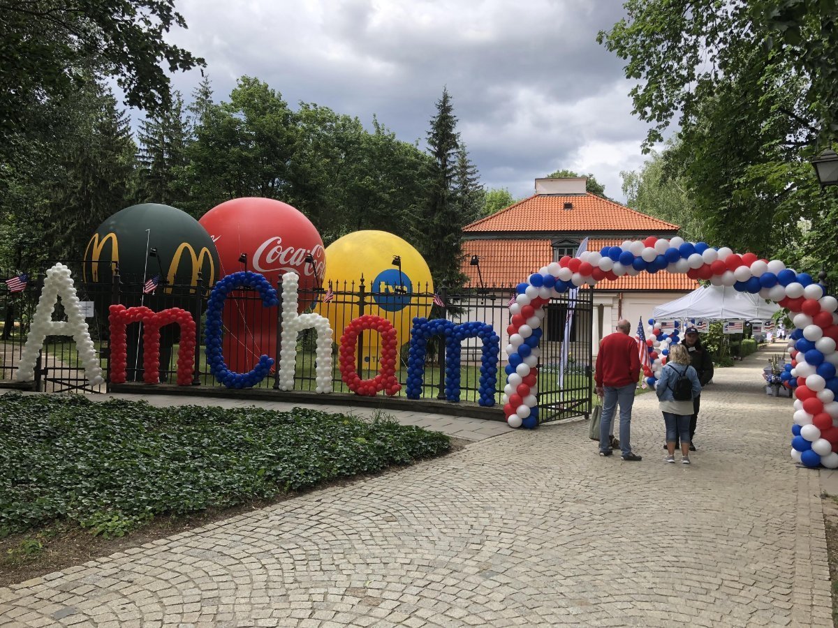 Red, blue and white AmCham logo and balloon arch at the Independance Day Picnic in Poland.