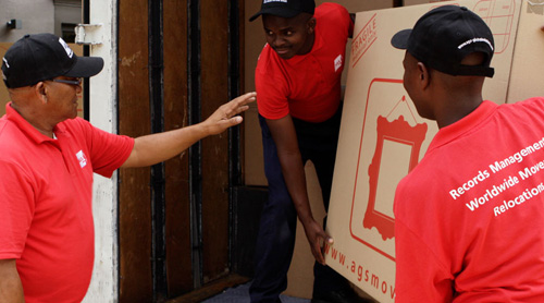 Men loading a truck with a big carton